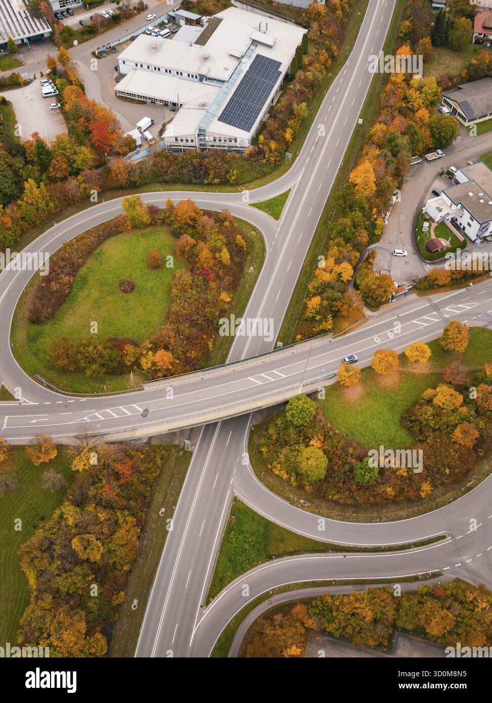 Incrocio stradale con rotonda circondato da aree verdi e alberi autunnali da una vista a volo d'uccello, Dornstetten, Freudenstadt, Germania Foto Stock
