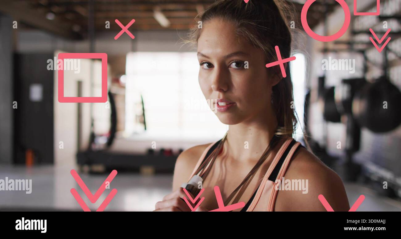 Con la corda per saltare, donna che indossa abbigliamento sportivo pesca nell'area di allenamento pesi con panca e grafica rosa Foto Stock