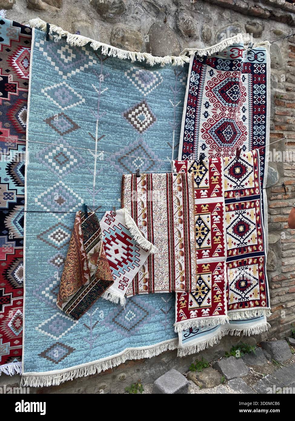 Tappeti multicolori e tessuti a mano esposti in un mercato in una città georgiana. Foto Stock