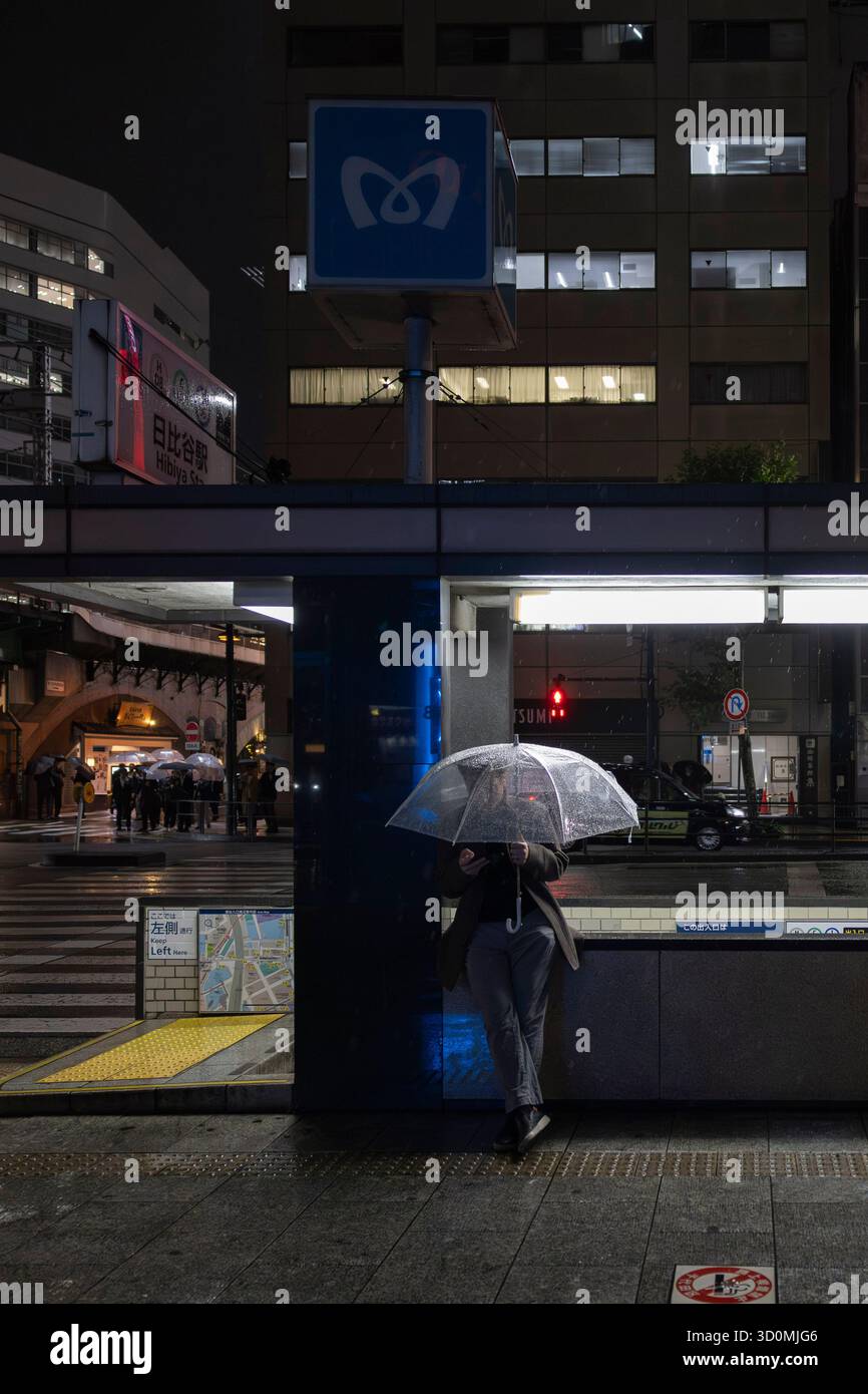 Tokyo, Giappone. 22 ottobre 2025. Un uomo tiene un ombrello mentre si trova di fronte a una stazione della metropolitana di Tokyo. Credito: SOPA Images Limited/Alamy Live News Foto Stock