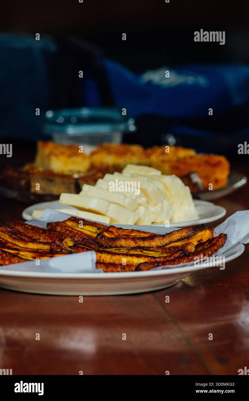 Platani fritti e formaggio tradizionale costaricano su un tavolo rustico Foto Stock