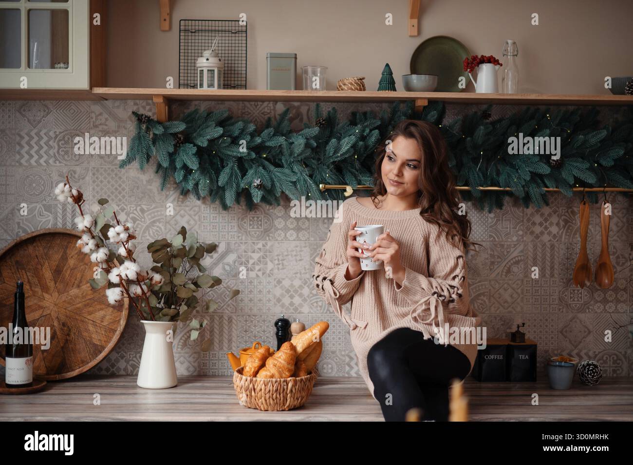 Donna che si gusta il caffè nella cucina Festive Foto Stock