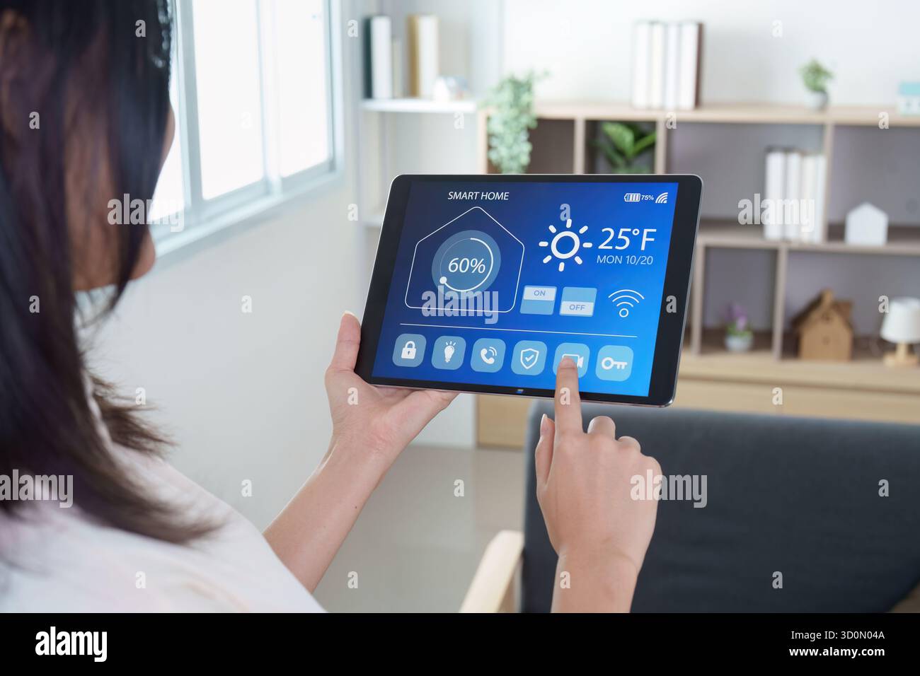 Casa intelligente. Donna che controlla un sistema di casa intelligente su un tablet. Foto Stock