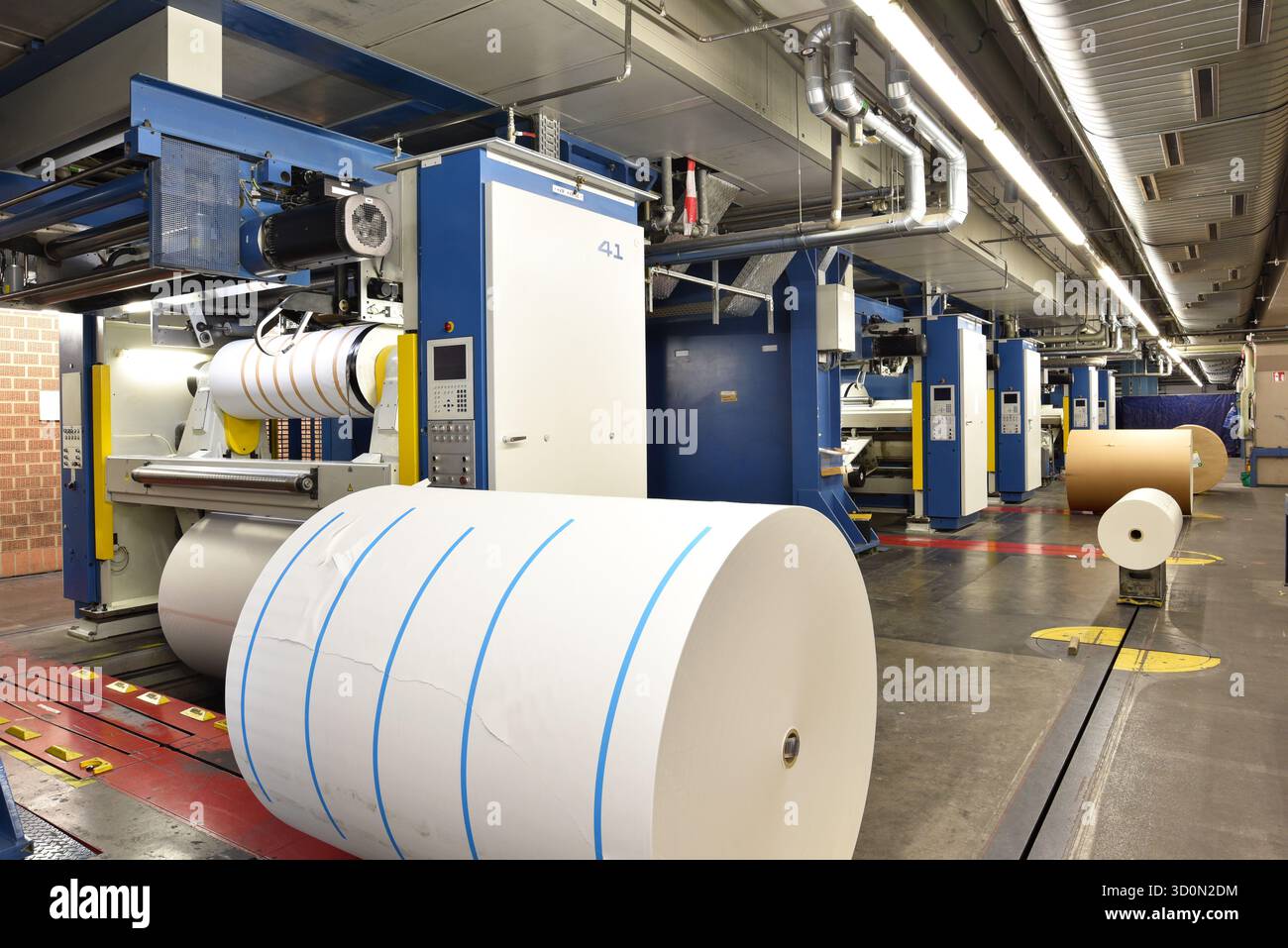 Rotoli di carta e macchine di stampa offset in un grande negozio di stampa per la produzione di giornali e riviste Foto Stock
