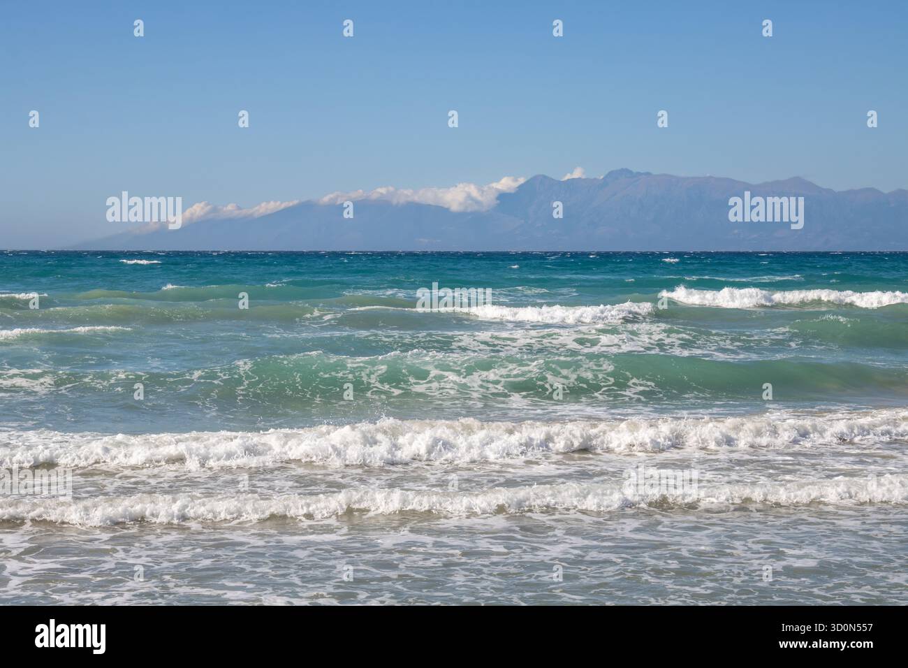 Mare Ionio con onde spettacolari durante una tarda giornata estiva. Montagne albanesi sullo sfondo. Cielo blu con nuvole bianche. A nord dell'isola di Corfù ( Foto Stock