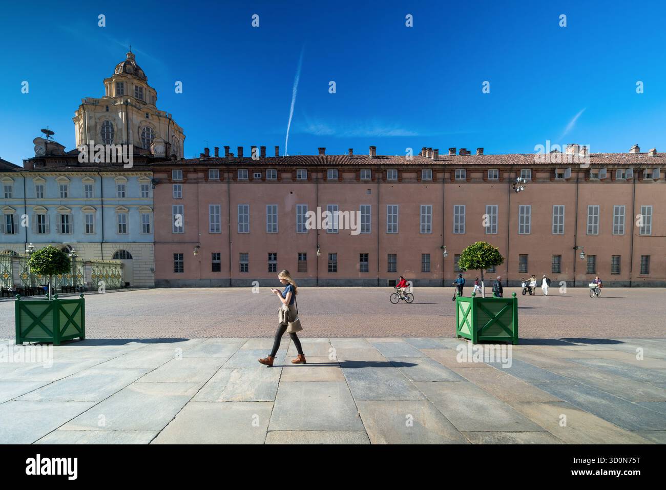 Persone che camminano e pedalano attraverso Piazza Castello con la storica cupola della Sacra Sindone visibile sullo sfondo. Torino, Italia. 10.06.2 Foto Stock