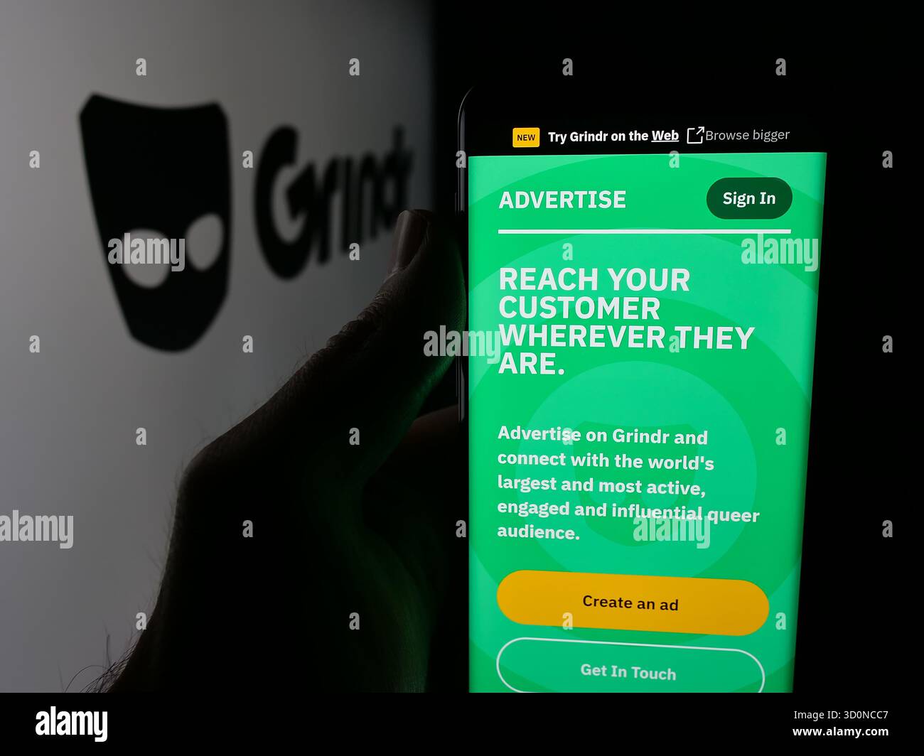 Stoccarda, Germania - 10-15-2025: Persona che tiene il cellulare con pagina web della società di social media LGBT Grindr Inc sullo schermo davanti al logo. Fil Foto Stock