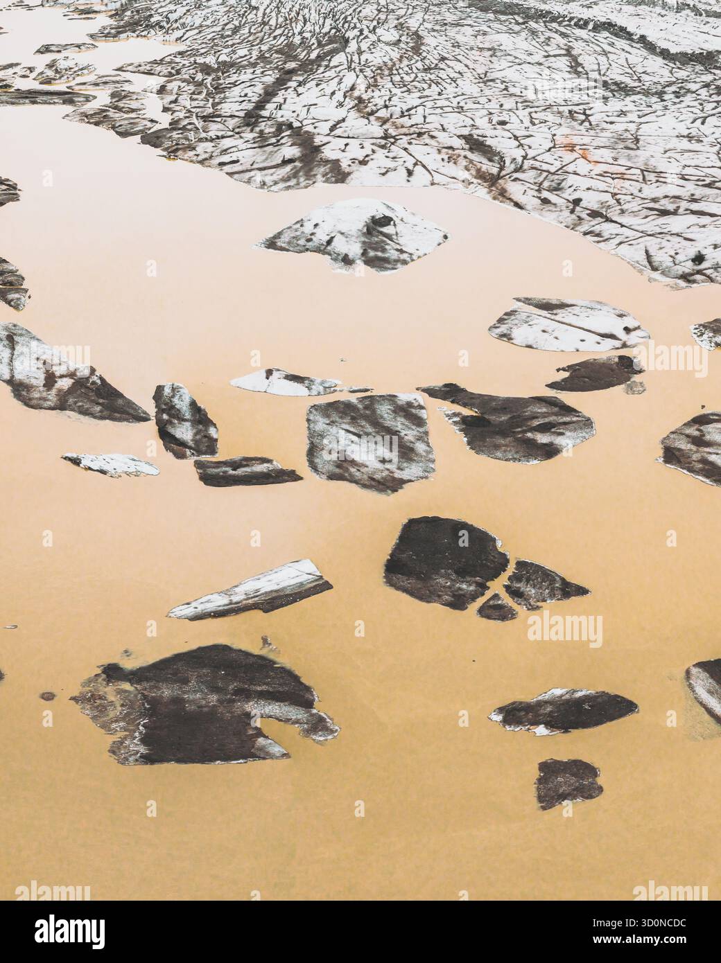 Vista aerea dei blocchi di ghiaccio glaciali sparsi nelle acque color ocra sotto l'imponente ghiacciaio Svínafellsjökull, Svínafellsjökull, Sveitarfélagið Hornafjörður, Islanda. Foto Stock