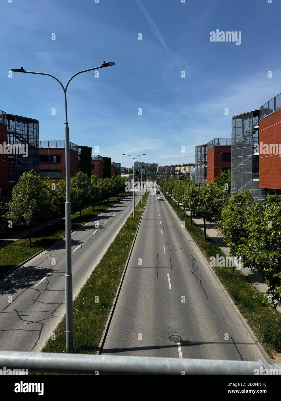 Ampia strada moderna a Brno, Repubblica Ceca, con alberi, edifici moderni e cielo azzurro in una giornata di sole. Paesaggio urbano con modernità - Immagine stock catturata con smartphone