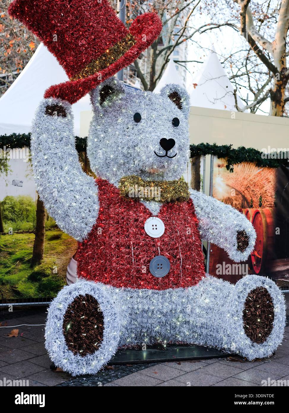 Berlino, Germania - 01 gennaio 2024: Decorazioni natalizie con orsacchiotto con cappello rosso e abiti luccicanti in un parco. Foto Stock