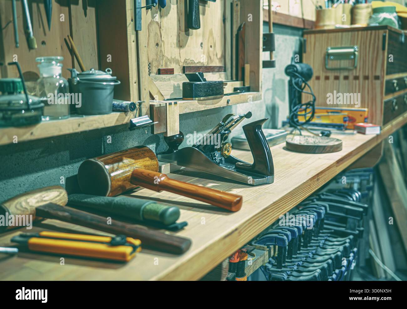 Autentico laboratorio di lavorazione del legno con utensili d'epoca sul tavolo, tra cui un mazzuolo di legno, una pialla manuale in ghisa di alta qualità e metallo Foto Stock
