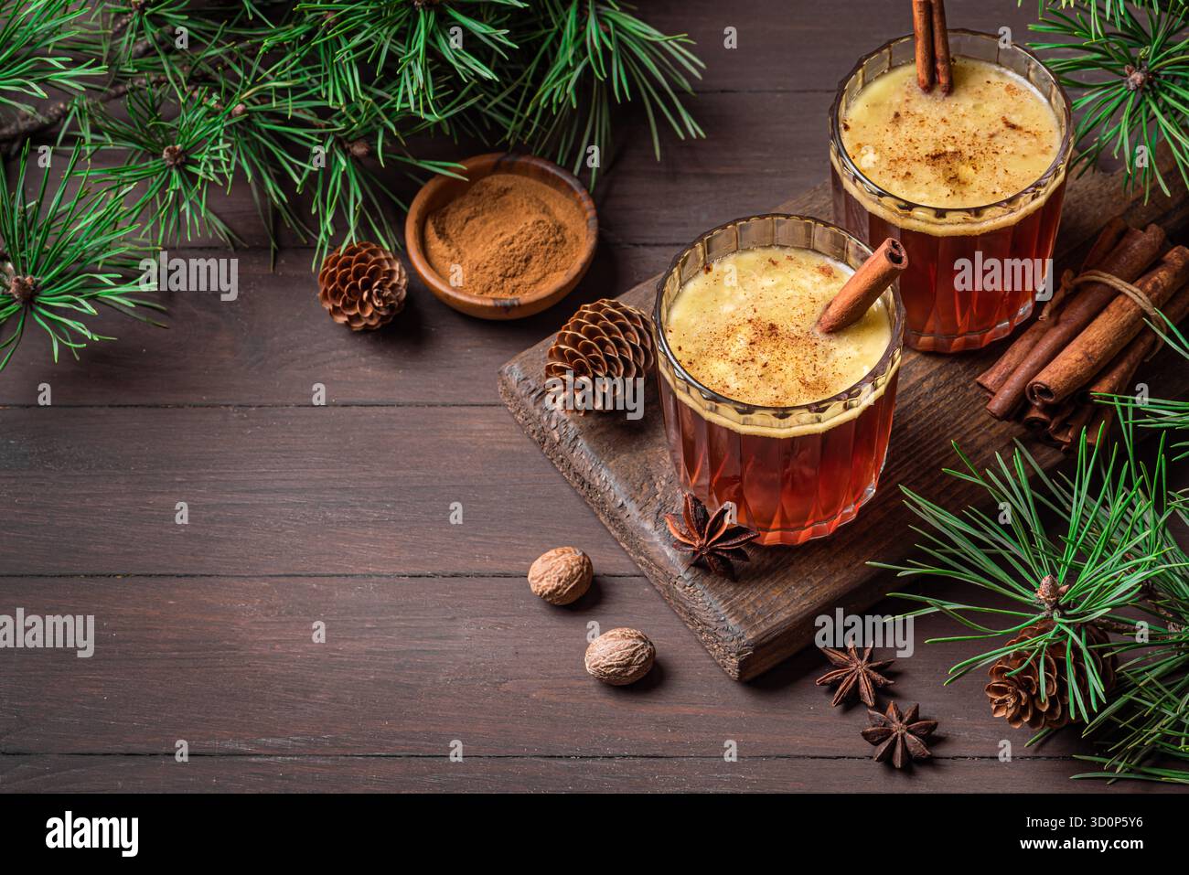 Cocktail caldo al rum con cannella per Natale e le vacanze invernali. Bevanda calda calda e alcolica fatta in casa con rami di pino, spazio per fotocopie. Foto Stock