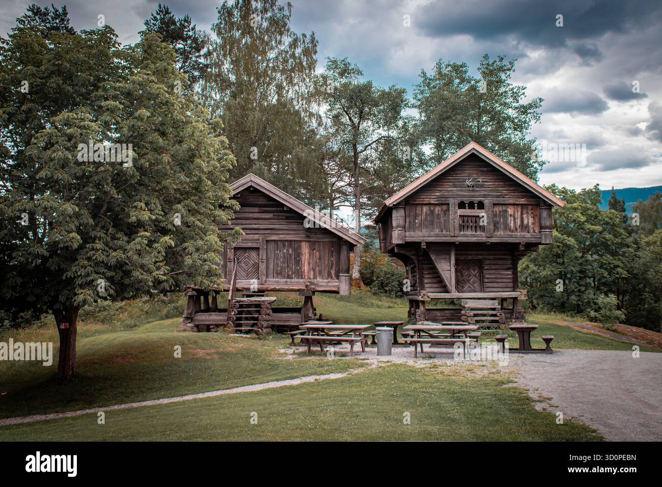 Cabine norvegesi in legno con tavoli e panchine davanti. Foto Stock