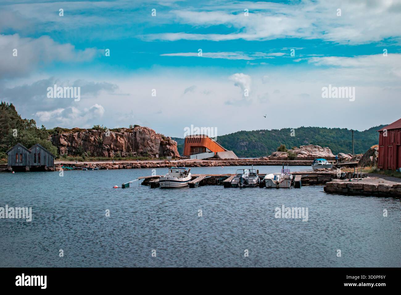 Una fila di barche colorate con barche attraccate all'interno, che si riflettono sull'acqua calma. Foto Stock