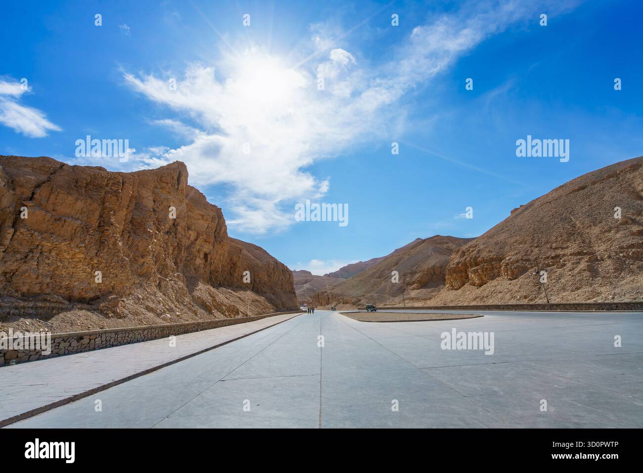 Un'ampia strada asfaltata attraversa le aride colline rocciose sotto un cielo luminoso. Il contrasto tra il percorso moderno e il terreno antico è sorprendente. Valle del Ki Foto Stock