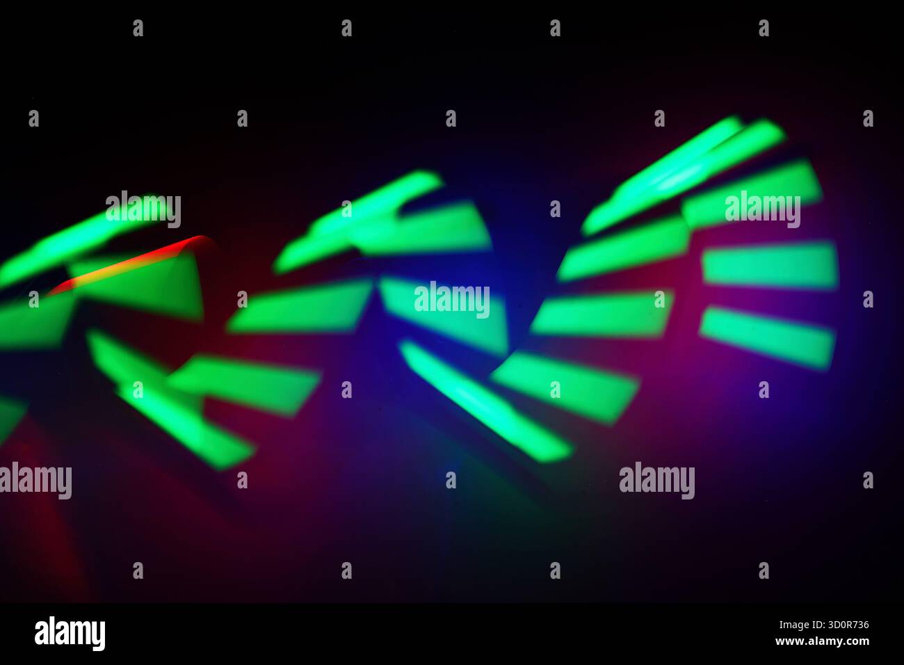 Sequenze di luce al neon. Immagine astratta di dinamiche tracce di luce verde su sfondo scuro. Foto Stock