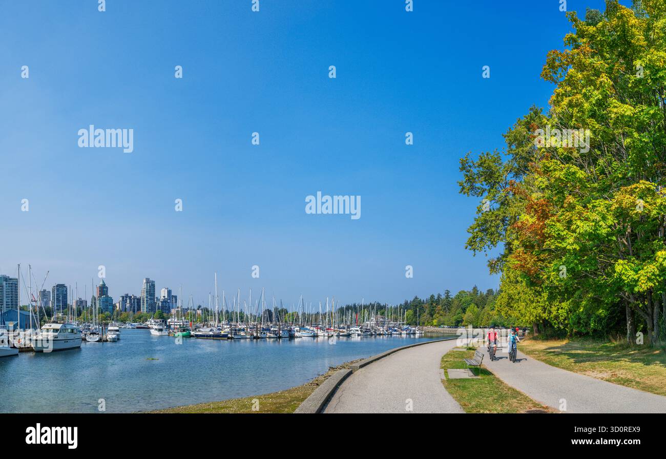 Marina e ciclista sul Seawall Path con lo skyline della città alle spalle, Stanley Park, Vancouver, British Columbia, Canada Foto Stock