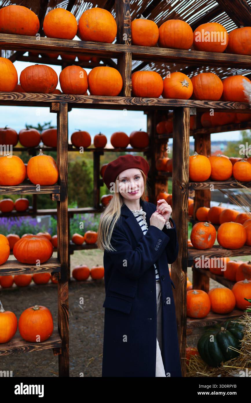 Bella donna in berretto Bordeaux alla zucca, che celebra le vibrazioni autunnali e la stagione del raccolto. Foto Stock