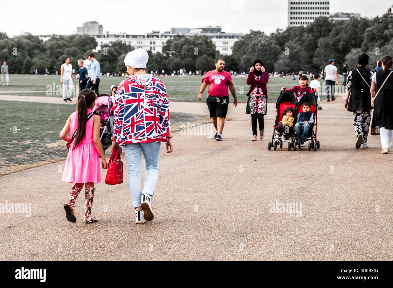 Persone di diversa provenienza camminano e si rilassano a Hyde Park, Londra, in una giornata di sole. Foto Stock