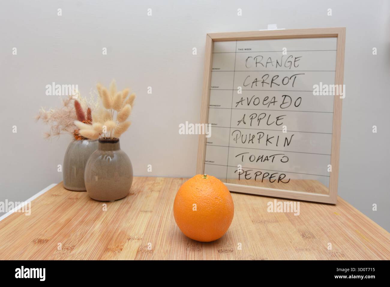 Una tavola e un'arancia indicano quale frutta mangiare il lunedì Foto Stock