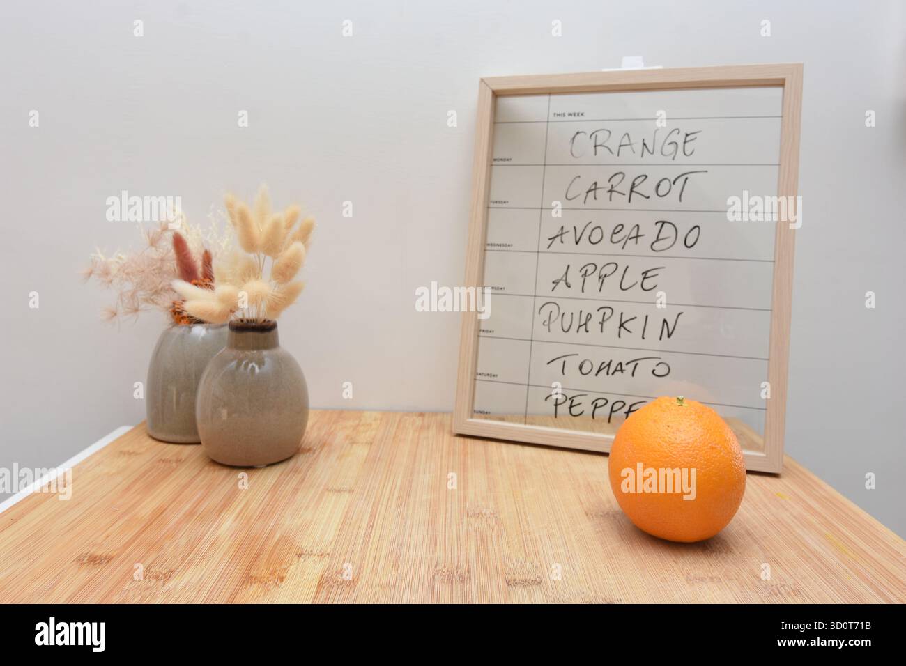 Una tavola e un'arancia indicano quale frutta mangiare il lunedì Foto Stock
