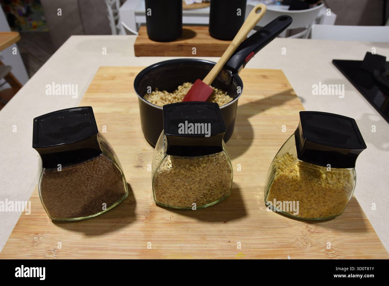 vari tipi di cereali pronti per essere cotti e una pentola contenente cereali già cotti Foto Stock