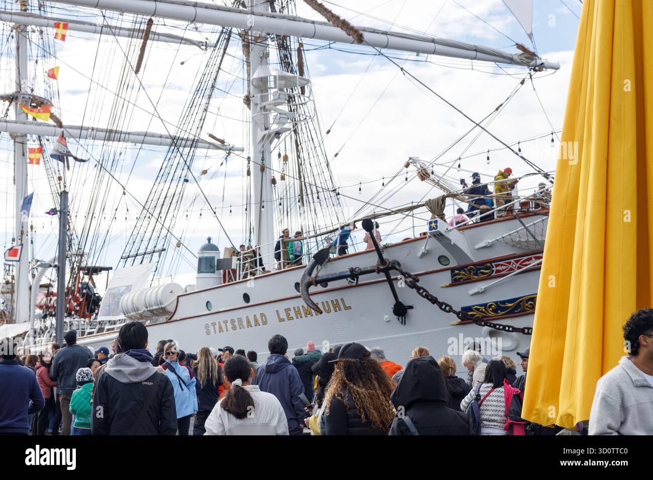 Vancouver Nord - Canada - 19 ottobre 2025: Grande folla che guarda l'alto vascello norvegese Statsraad Lehmkuhl attraccato sul lungomare con scafo bianco e lettera oro Foto Stock