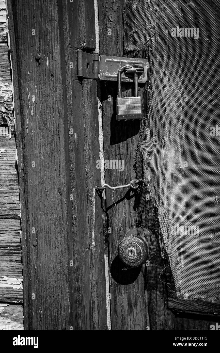 Una serie di serrature e serrature su una portiera usurata e resistente agli agenti atmosferici. Foto Stock