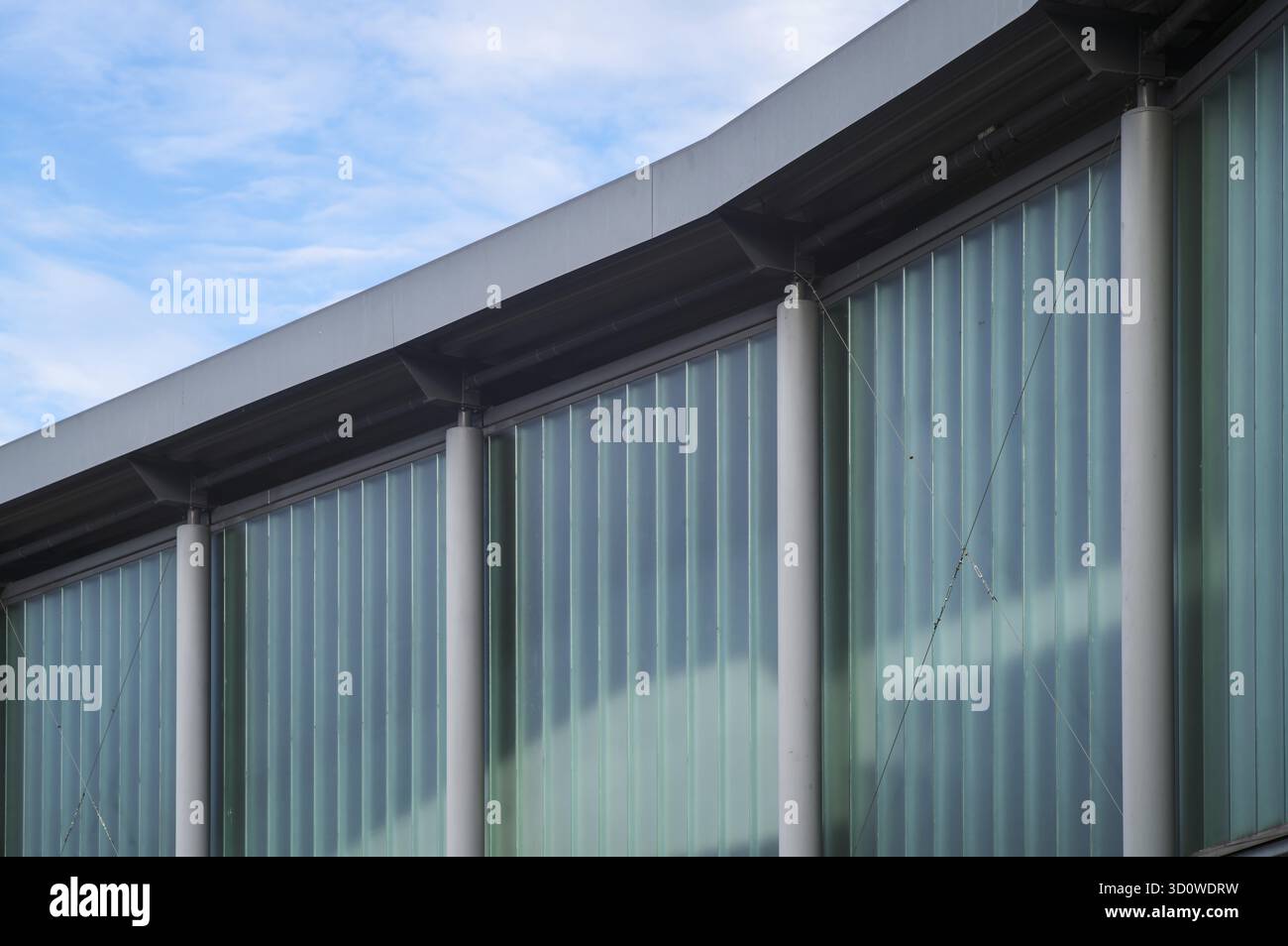 Borken, NRW, Germania, RModern, dettagli della facciata dell'edificio che mostrano pareti in vetro traslucido e pilastri in cemento sotto il cielo Foto Stock