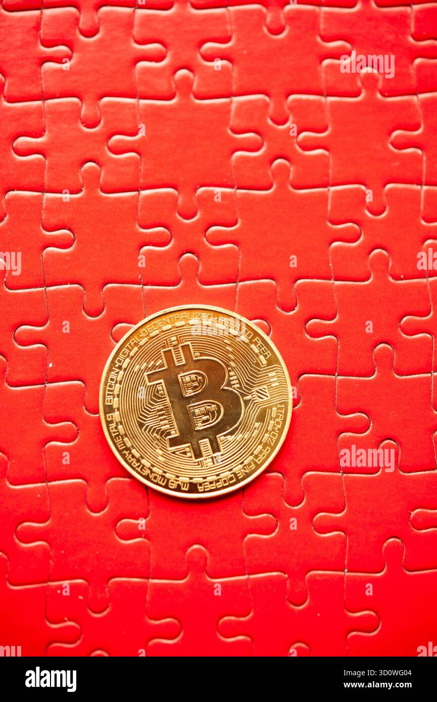 Moneta bitcoin d'oro su pezzi di puzzle rossi sfondo che simboleggia il concetto di criptovaluta e la rete finanziaria Foto Stock