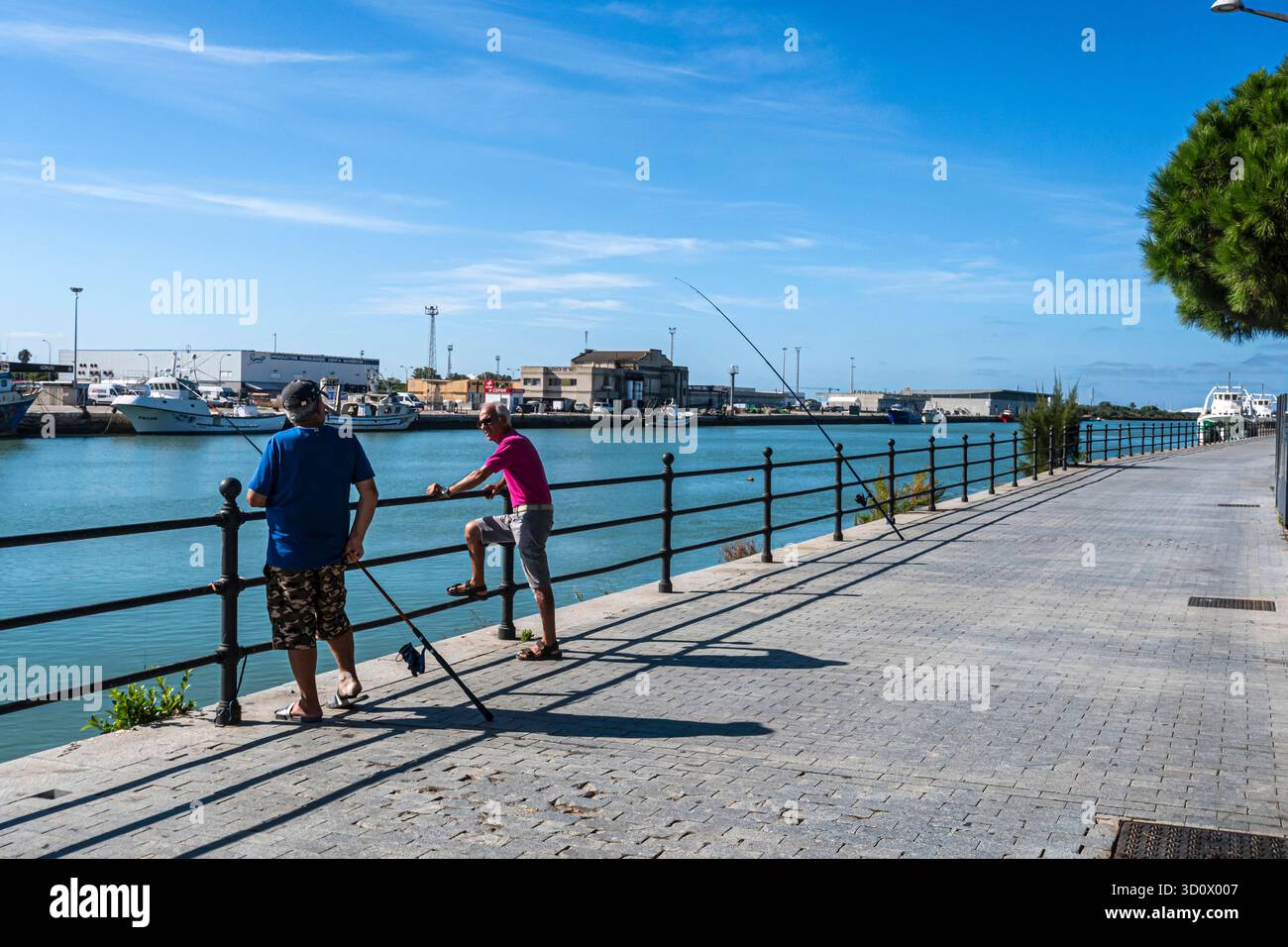 Due anziani che pescano sul fiume Guadalete nella città costiera di Puerto de Santa María, Cádiz, Andalusia, Spagna. Foto Stock