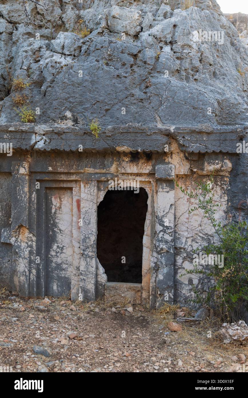 Foto verticale all'aperto con l'ingresso alla tomba dorica di Acdam nell'antica città di Antiphellos. Un parco pubblico a Kas, in Turchia Foto Stock