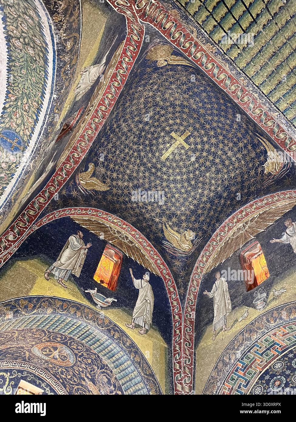 Primo piano della volta a mosaico del V secolo nel Mausoleo di Galla Placidia con croce d'oro e figure di santi. Ravenna, Italia. UNESCO. - Immagine stock catturata con smartphone
