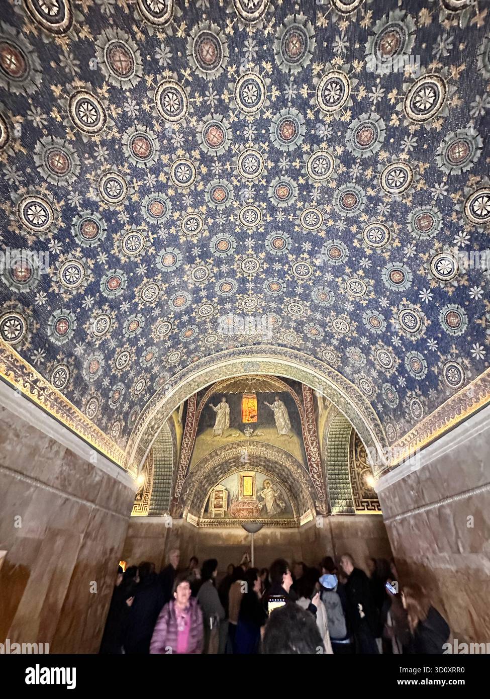 Interno del Mausoleo di Galla Placidia con mosaici di cielo stellato blu e folle di turisti che visitano il sito UNESCO di Ravenna, Italia. - Immagine stock catturata con smartphone