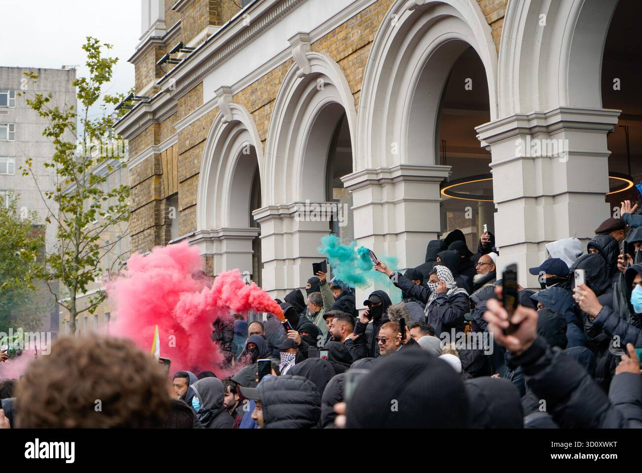 Le bombe fumé verdi e rosse sono schierate dai contro i manifestanti, simboleggiando la bandiera della Palestina Foto Stock