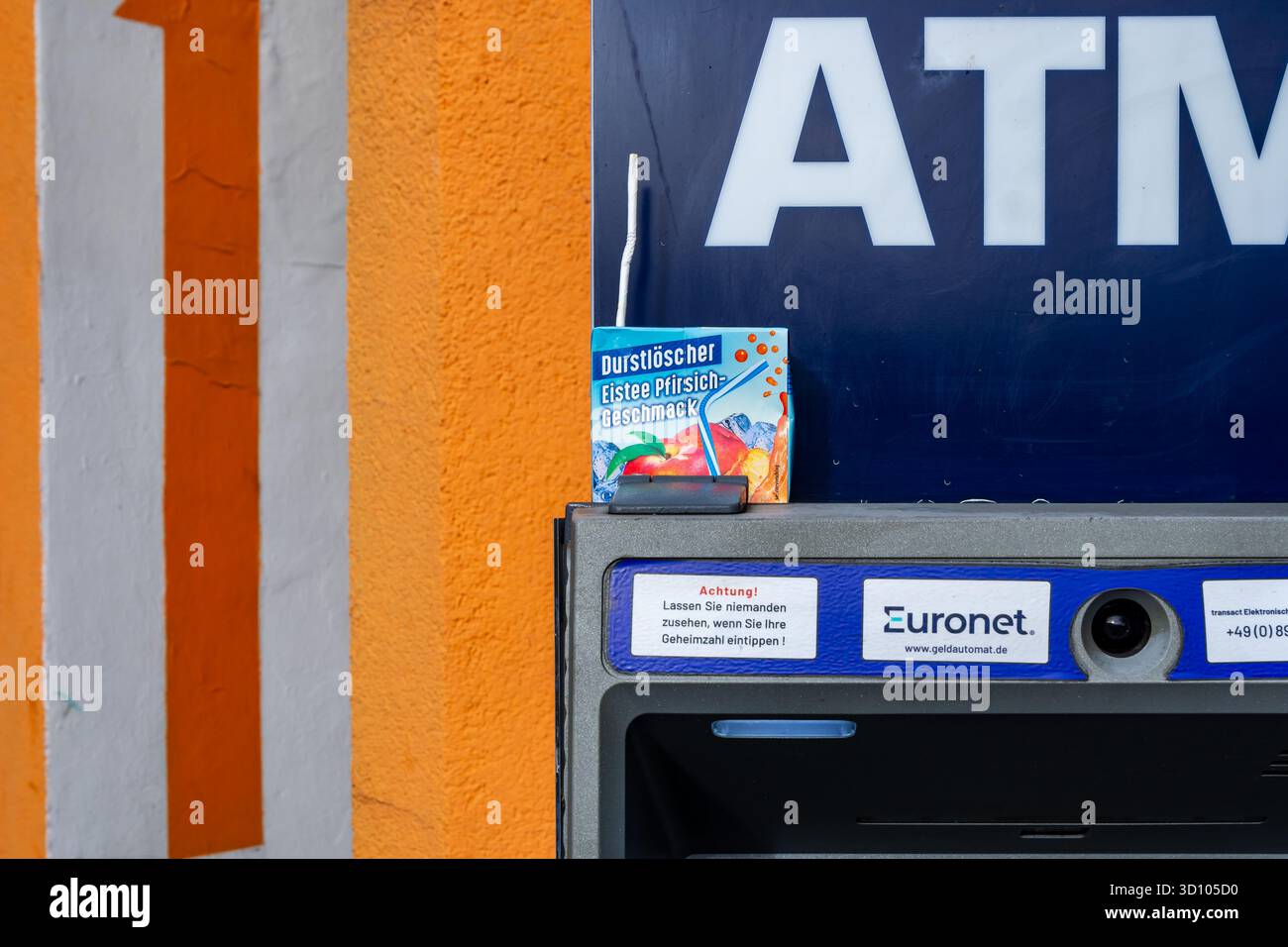 Foto ravvicinata di un cartone di tè ghiacciato alla pesca “Durstlöscher” lasciato in cima a un bancomat Euronet di Berlino, Germania. Foto Stock