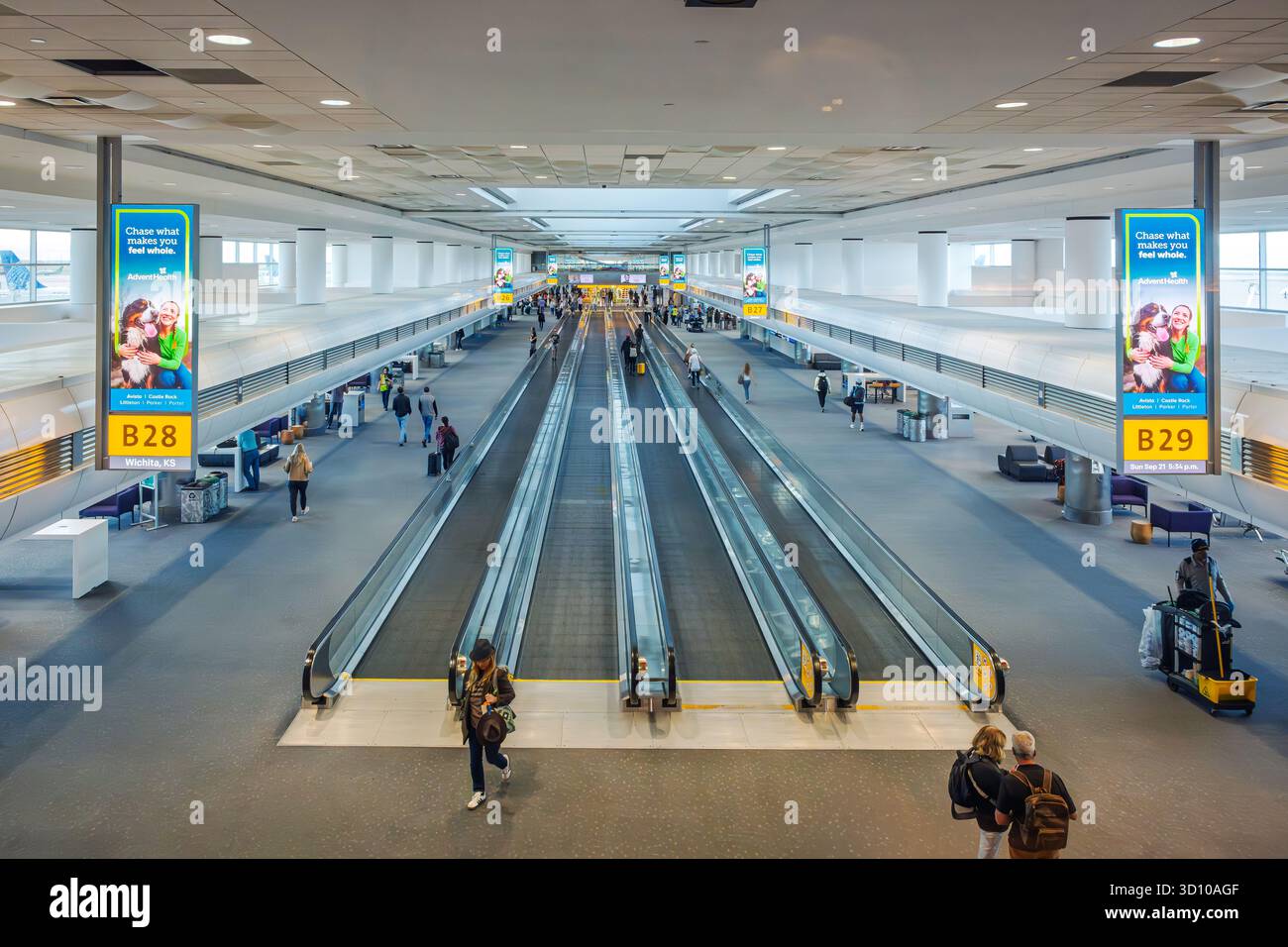 Assaggiatori che viaggiano a piedi e si spostano attraverso un importante terminal dell'aeroporto internazionale di Denver, uno dei più grandi degli Stati Uniti. Foto Stock