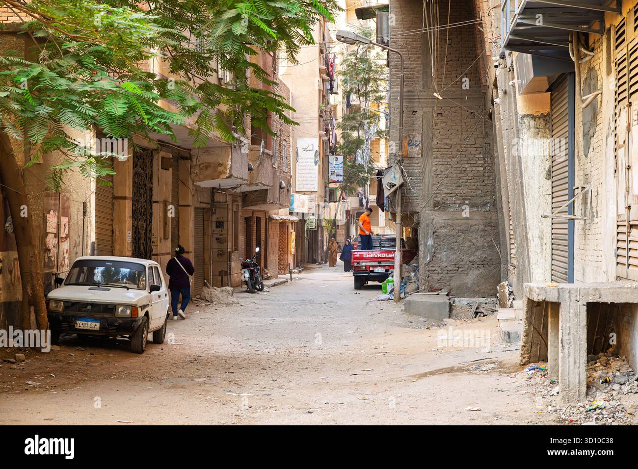 Una strada secondaria stretta e non asfaltata con case e negozi nella città vecchia del Cairo, in Egitto. Foto Stock