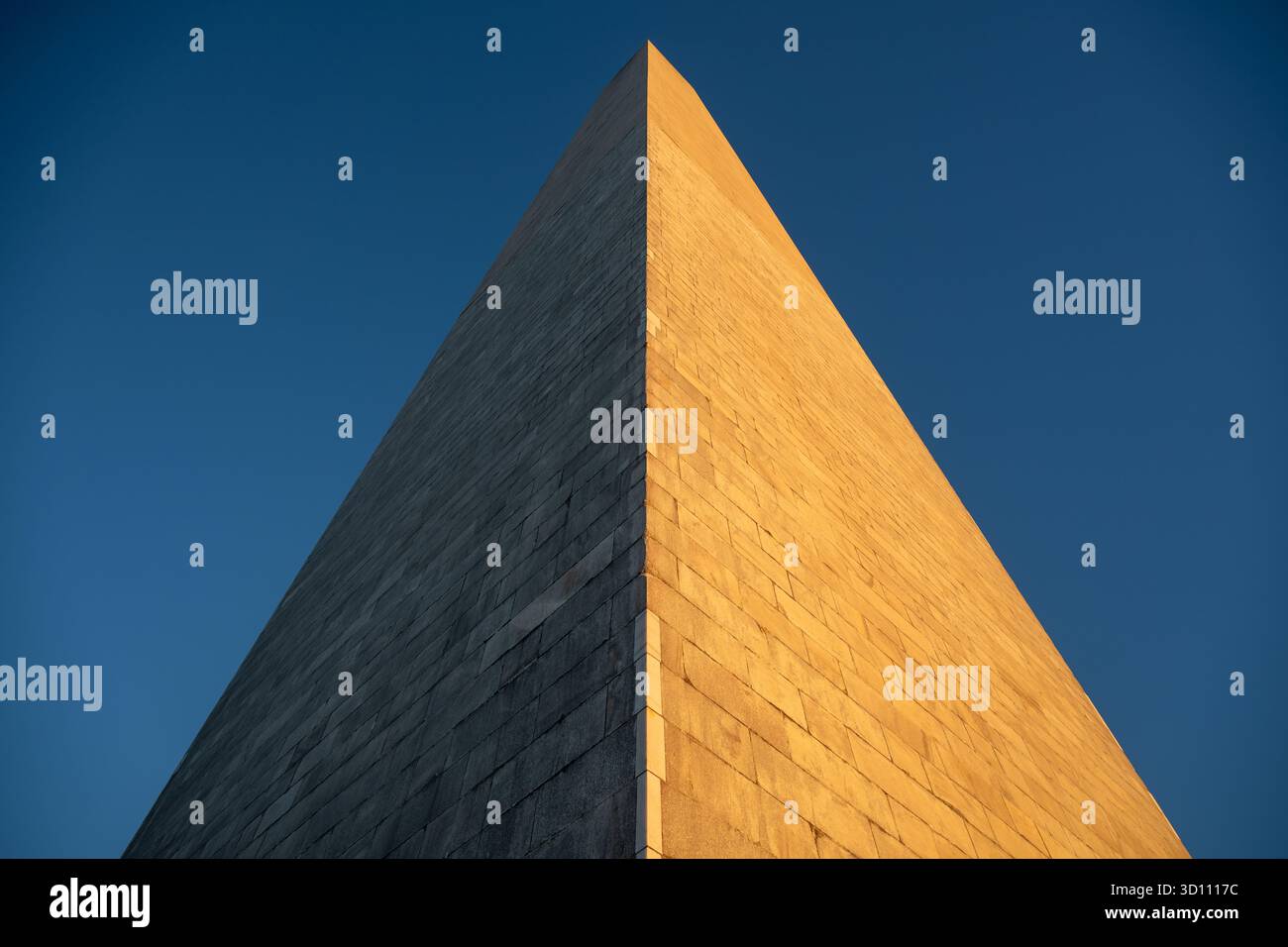 Washington Monument al tramonto Washington DC USA // WASHINGTON DC - la parte superiore del Washington Monument è illuminata dal sole che tramonta, proiettando un bagliore dorato su un lato mentre l'altro rimane in ombra. Questo iconico obelisco sul National Mall commemora George Washington, il primo presidente degli Stati Uniti. Completato nel 1884 e dedicato nel 1885, era la struttura più alta del mondo, con i suoi 169,29 metri (555 piedi 5 1/8 pollici). Costruito in marmo, granito e gneiss di pietra blu, è un importante punto di riferimento nazionale. Foto Stock