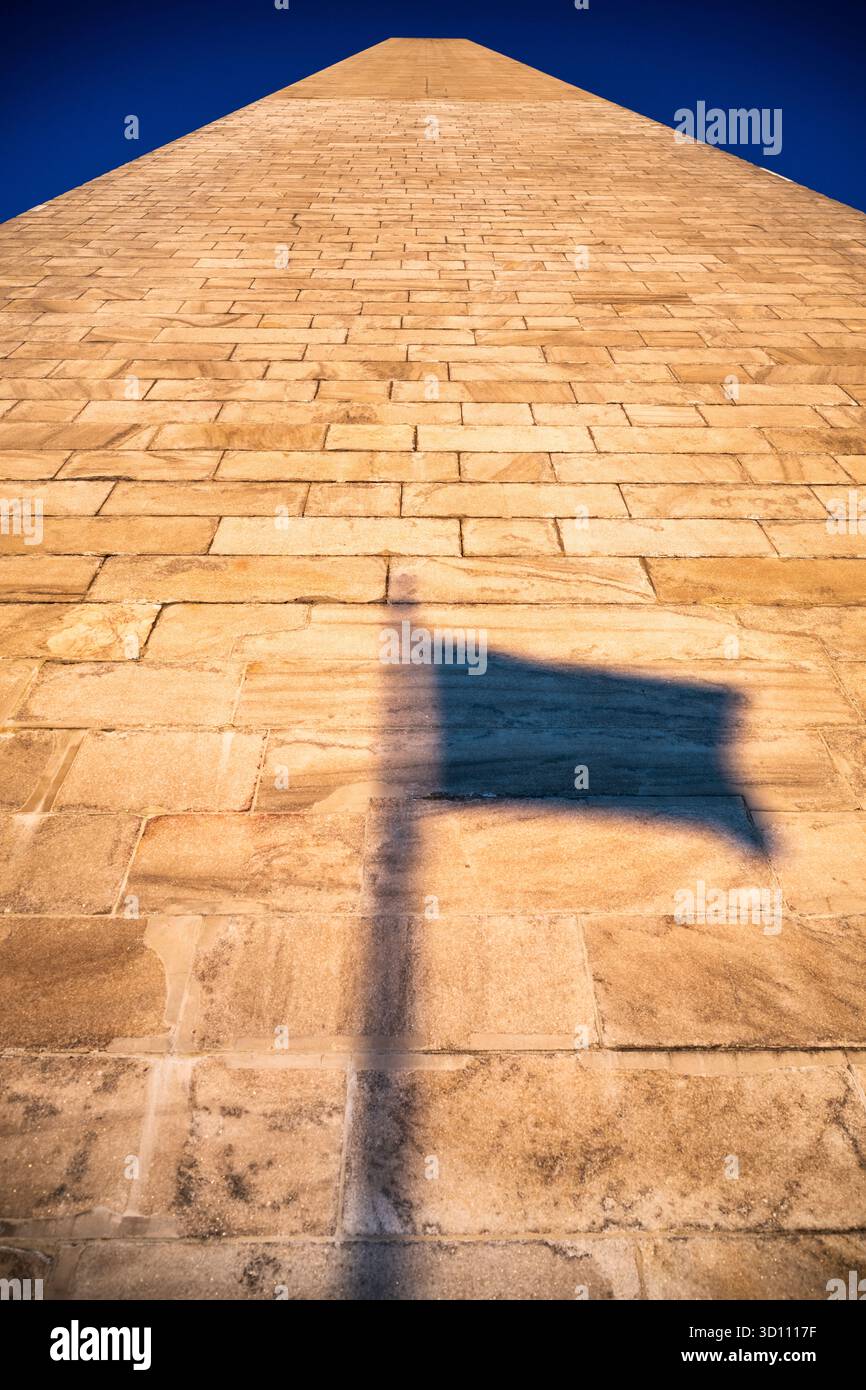 Washington Monument Flag Shadow Golden Hour Washington DC // WASHINGTON DC - il Washington Monument, un obelisco in onore di George Washington, presenta ombre di bandiere gettate sul suo esterno in marmo e granito al tramonto. Completato nel 1884, questo monumento nazionale è alto 169,046 metri (554 piedi 7 11/32 pollici). E' la struttura e l'obelisco in pietra piu' alti del mondo, un punto di riferimento centrale nel National Mall gestito dal National Park Service. Foto Stock