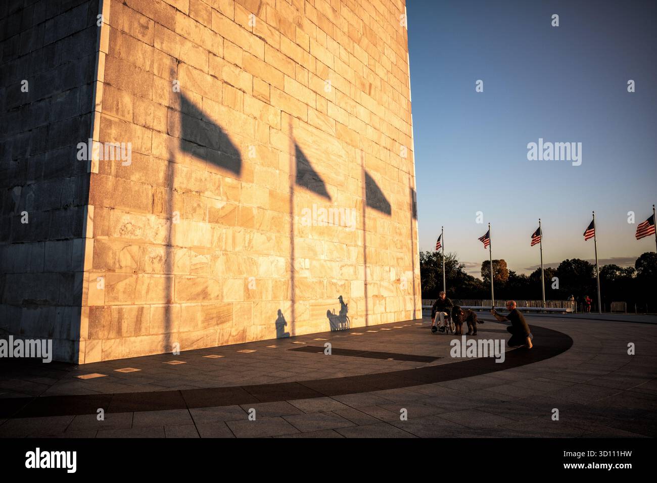 Washington Monument Golden Hour Sunlight Washington DC USA // WASHINGTON DC - il Washington Monument, un iconico obelisco che commemora George Washington, è illuminato dalla luce dell'ora d'oro del sole. Il suo esterno è costruito in marmo, granito e gneiss di pietra blu. Completato nel 1884, questo monumento è alto 169,294 metri (555 piedi e 1/8 pollici). Situato sul National Mall, è un importante punto di riferimento nella capitale della nazione, dove i visitatori sono spesso visti godendosi la luce della sera. Foto Stock