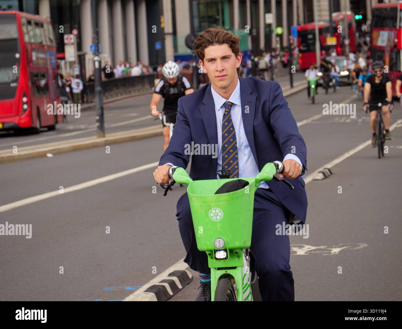 Impiegato pendolare che attraversa il London Bridge a bordo di una bicicletta elettrica Lime noleggiata, Inghilterra, Regno Unito Foto Stock