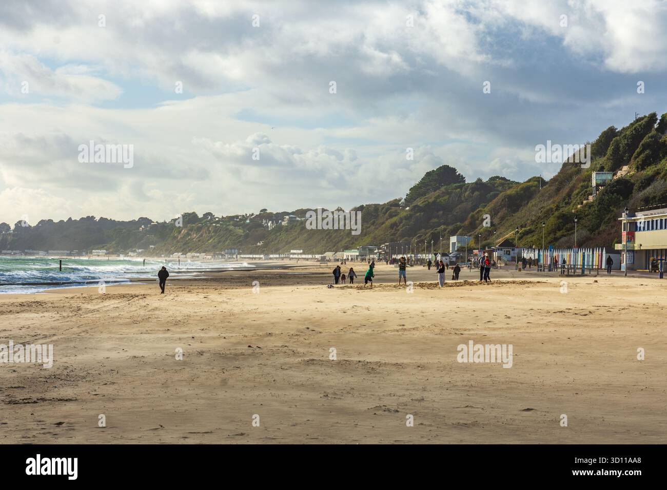 West Cliff Beach, Bournemouth, Regno Unito - 24 ottobre 2025: Piccolo gruppo di persone sulla spiaggia di sabbia quasi deserta. Foto Stock