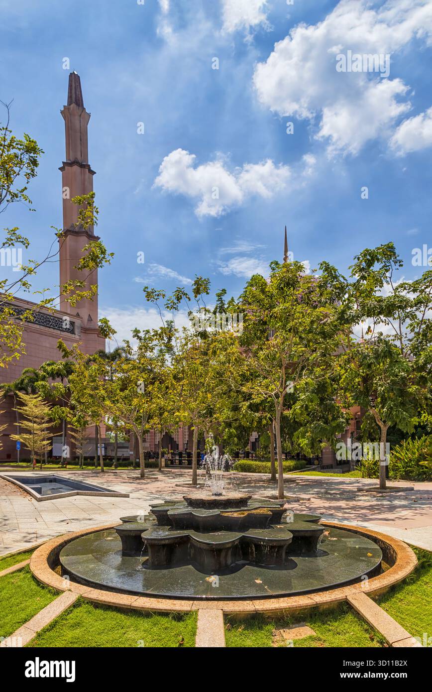 Edificio pubblico con moschea rosa e torre minareto circondato da un parco nella città di Putrajaya in Malesia. Foto Stock