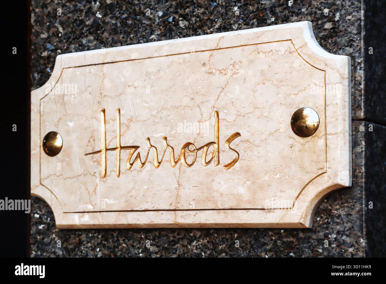 Londra, Regno Unito - 13 agosto 2022: Elegante targa Harrods in marmo con scritta in oro sulla parete esterna del dipartimento di lusso famoso in tutto il mondo Foto Stock