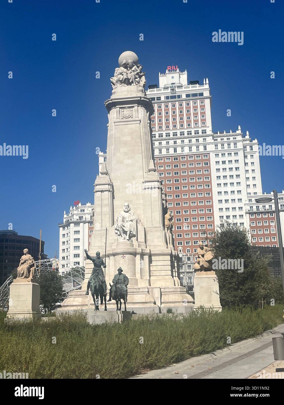 Monumento de Cervantes in Plaza de España a Madrid, Spagna, con l'hotel Riu Plaza España sullo sfondo in una soleggiata giornata estiva. - Immagine stock catturata con smartphone