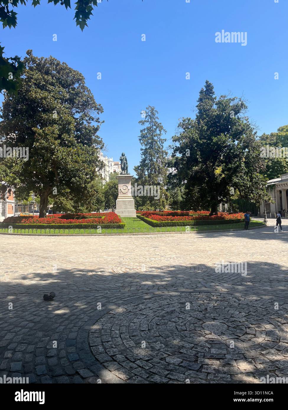 Vista laterale del monumento vicino al Museo del Prado e al Real Jardín Botánico di Madrid, circondato da alberi e aiuole in una soleggiata giornata estiva. Foto Stock