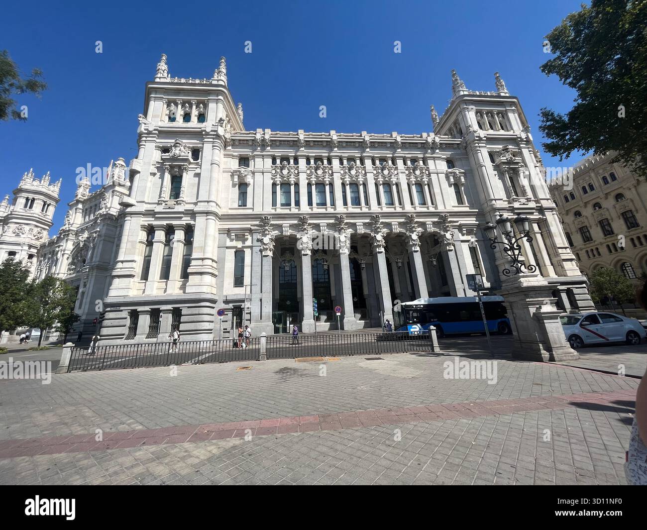 Vista laterale del Palacio de Cibeles di Madrid con eleganti archi e facciata dettagliata sotto il sole estivo. - Immagine stock catturata con smartphone