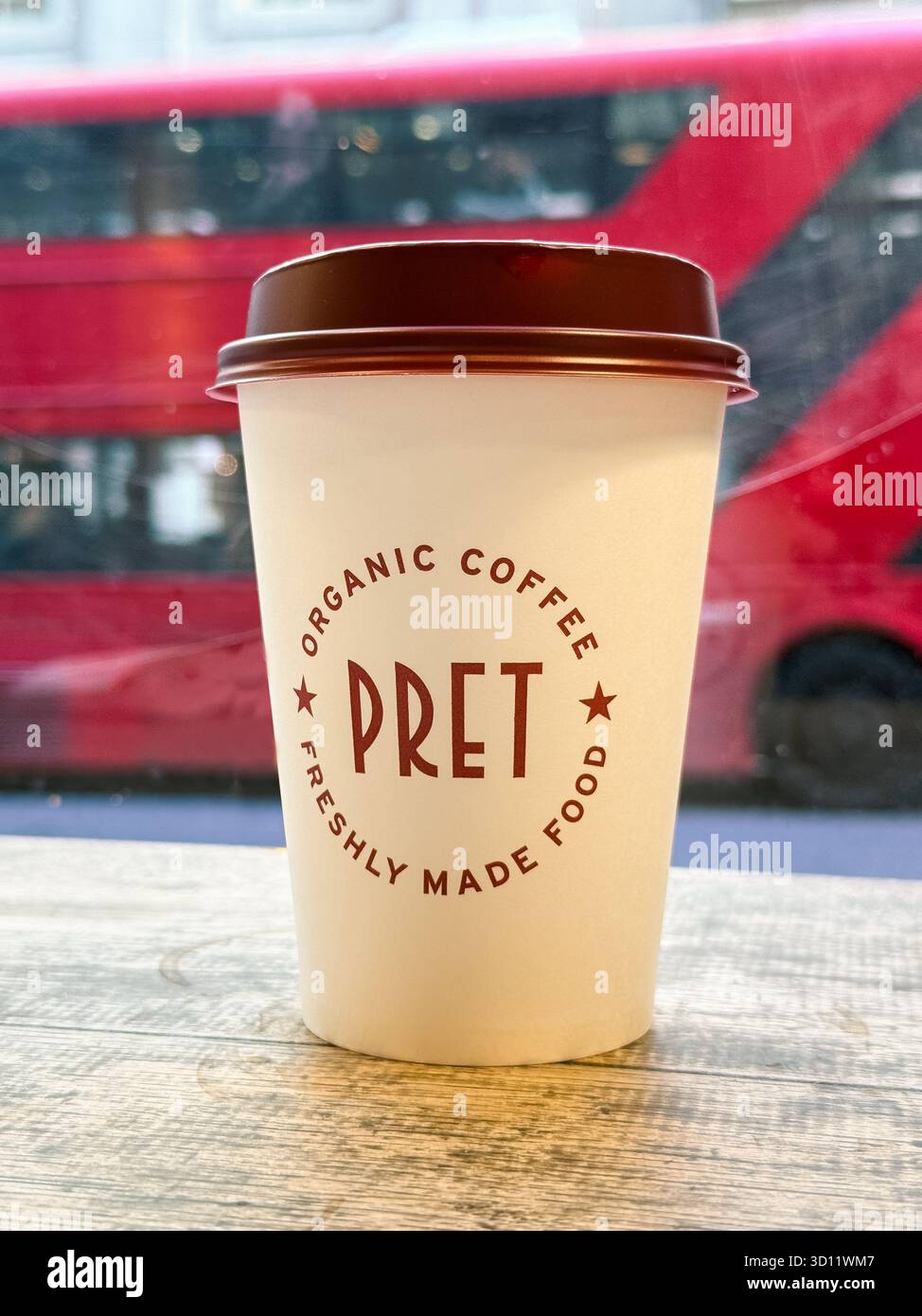 Londra, Regno Unito - 20 agosto 2025; tazza di caffè con marchio Pret presso la caffetteria Pret a Manger con autobus di Londra fuori dal campo Foto Stock