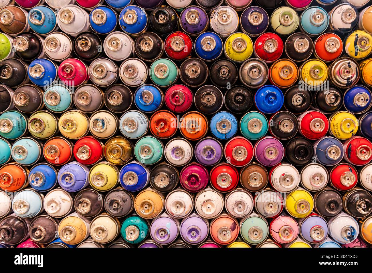 Bombolette di graffiti con vernice spray usate in una parete decorativa colorata sullo sfondo Foto Stock